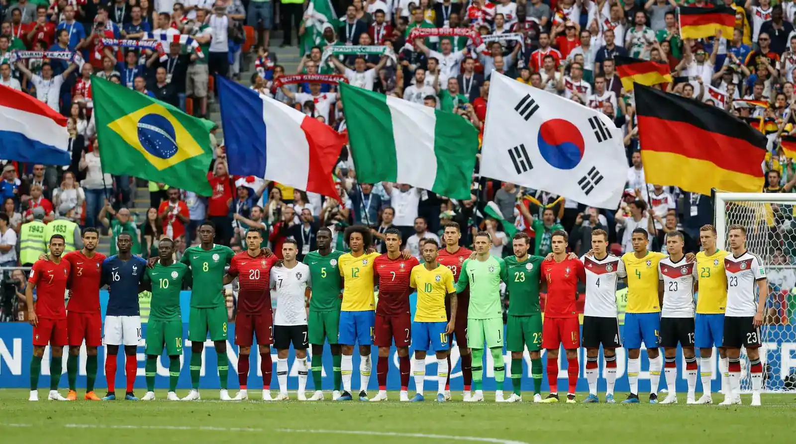 Joueurs de différentes équipes nationales alignés sur le terrain avec leurs drapeaux